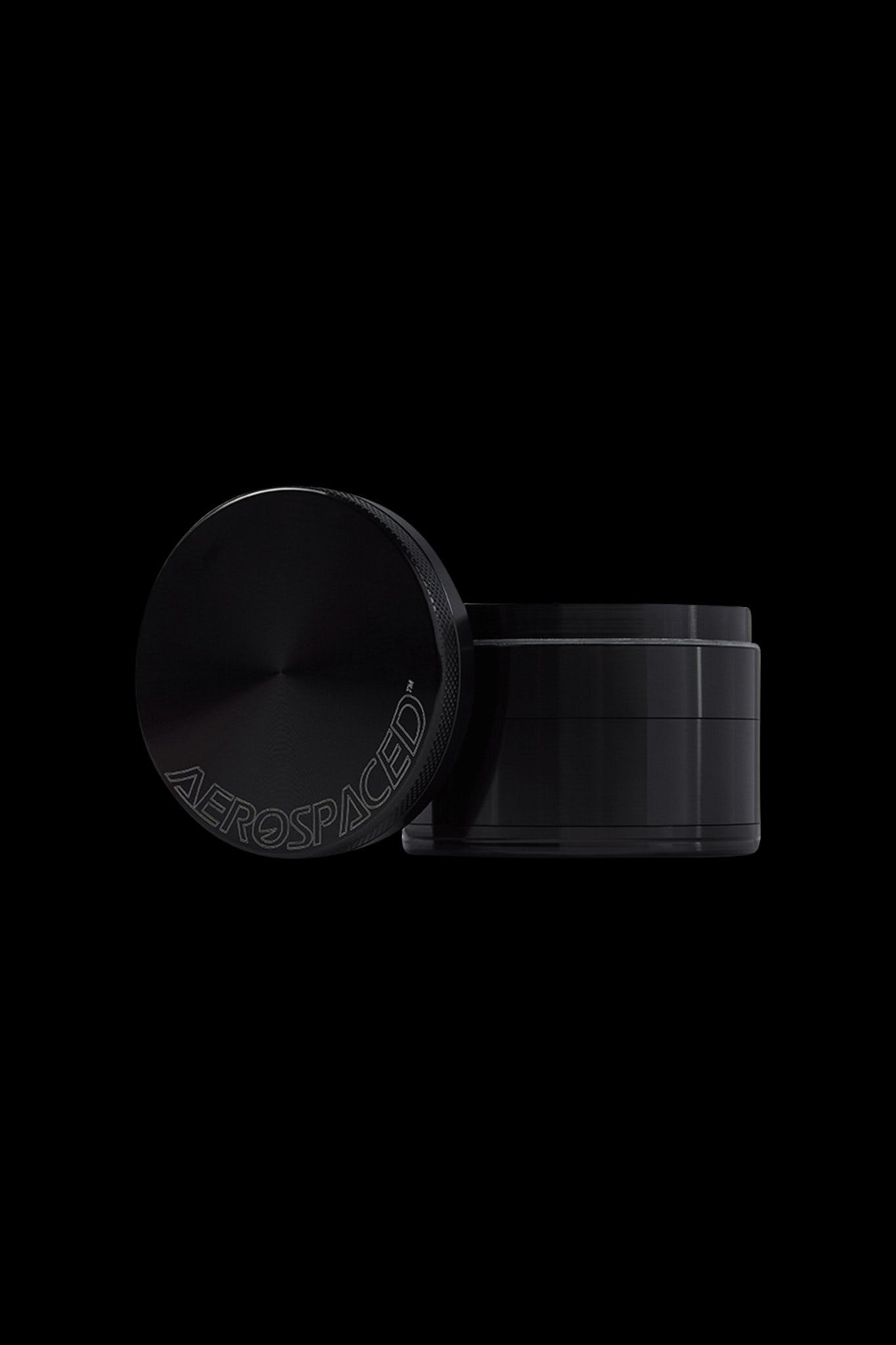 Black four-piece cannabis grinder with “AEROSPACED” etched around the lid.