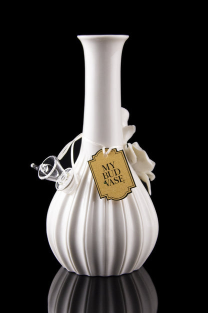 White glass water pipe with a decorative tag reading "My Bud Vase" and a glass bowl, reflected on a black surface.