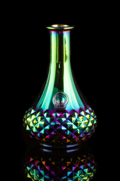 Iridescent glass water pipe with geometric pattern, studio shot.