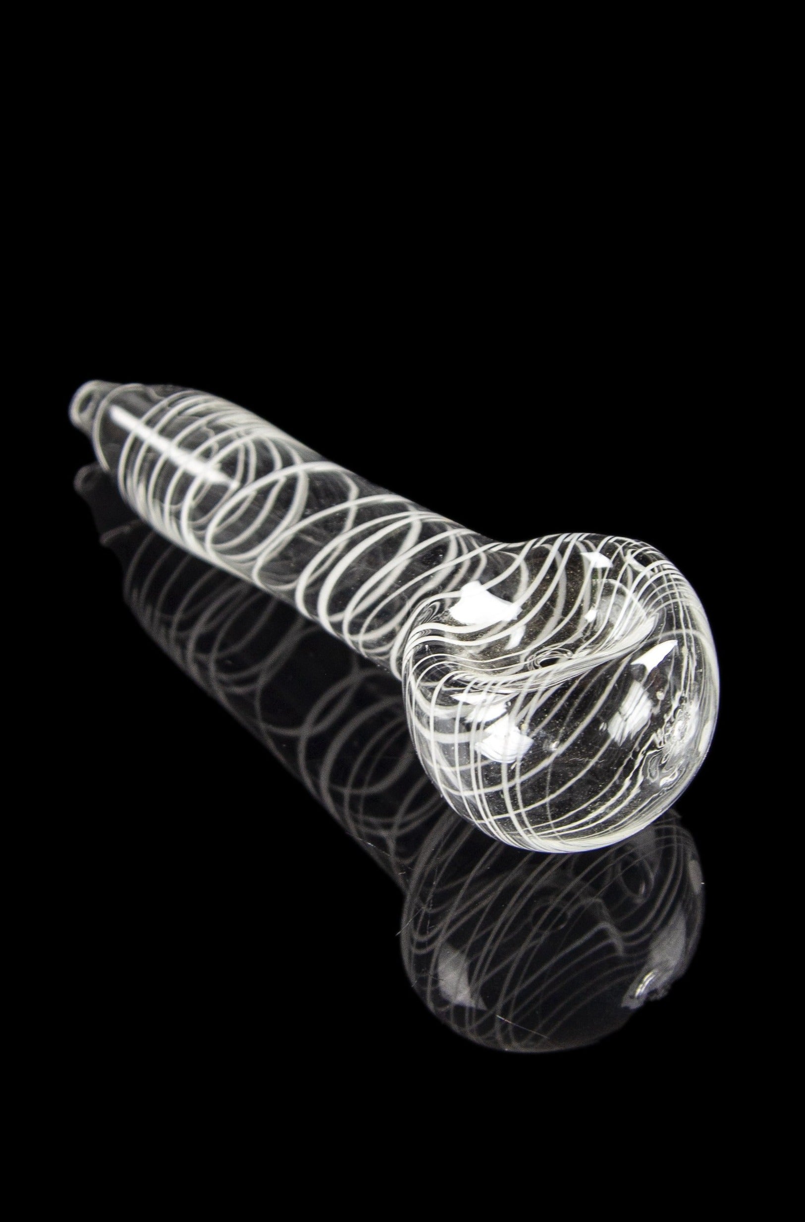 Clear glass pipe with white spiral detailing, reflecting on a black surface.