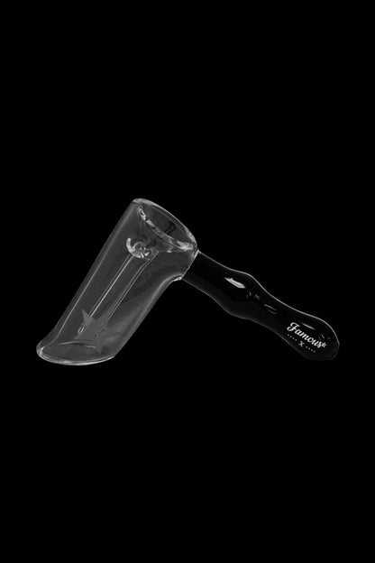 Angled side view of the Famous X Straight Hammer Bubbler Pipe on a black background showing its clear angled chamber and glossy black handle with the "Famous" logo.