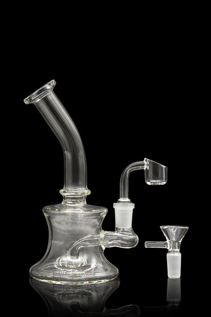 Clear glass water pipe (rig) with a quartz banger and ceramic insert, studio shot on black.