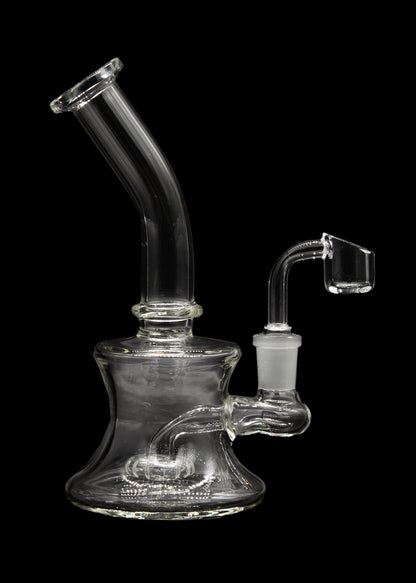 Clear glass dab rig with a quartz banger, isolated on a black background.