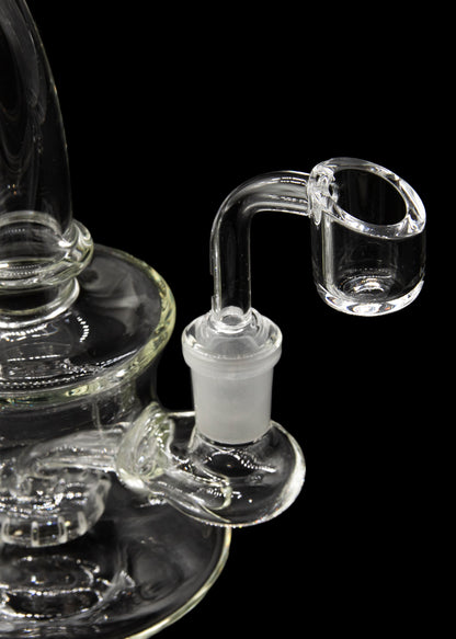 Clear glass dab rig with a quartz banger against a black background.