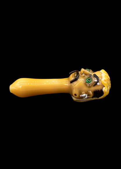 Yellow glass pipe with sculpted skull details.