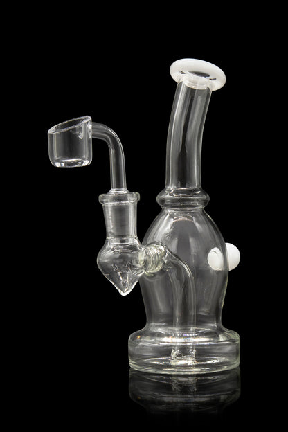 Clear glass dab rig with a quartz banger, illuminated against a black background.