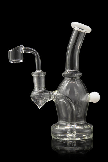 Clear glass dab rig with quartz banger, reflecting on a black surface.