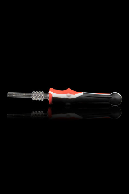 Glass dab tool with a patterned tip and red, white, and black handle, displayed with its reflection on a black background.