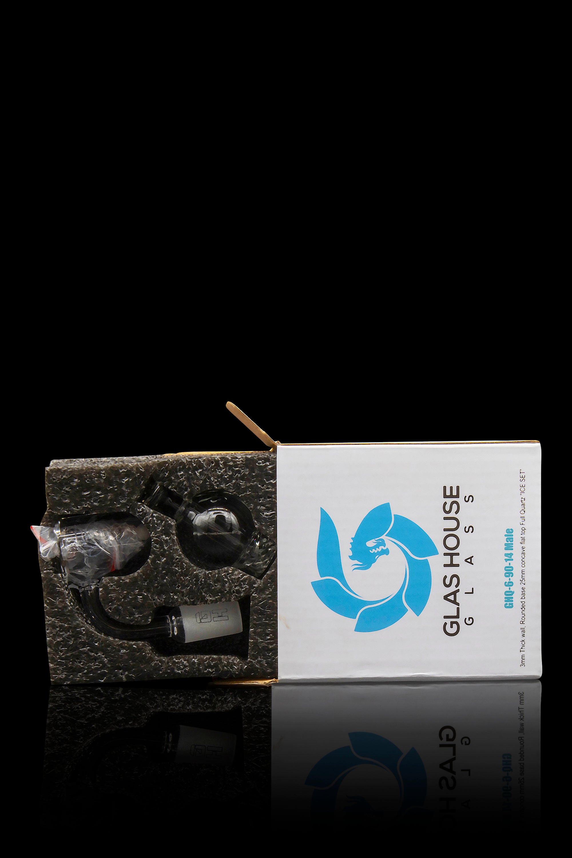 Glass House Glass packaging for a cannabis smoking accessory, reflecting on a glossy surface.