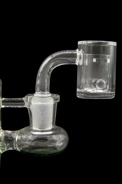 Clear glass dab rig with quartz banger, isolated on a black background.