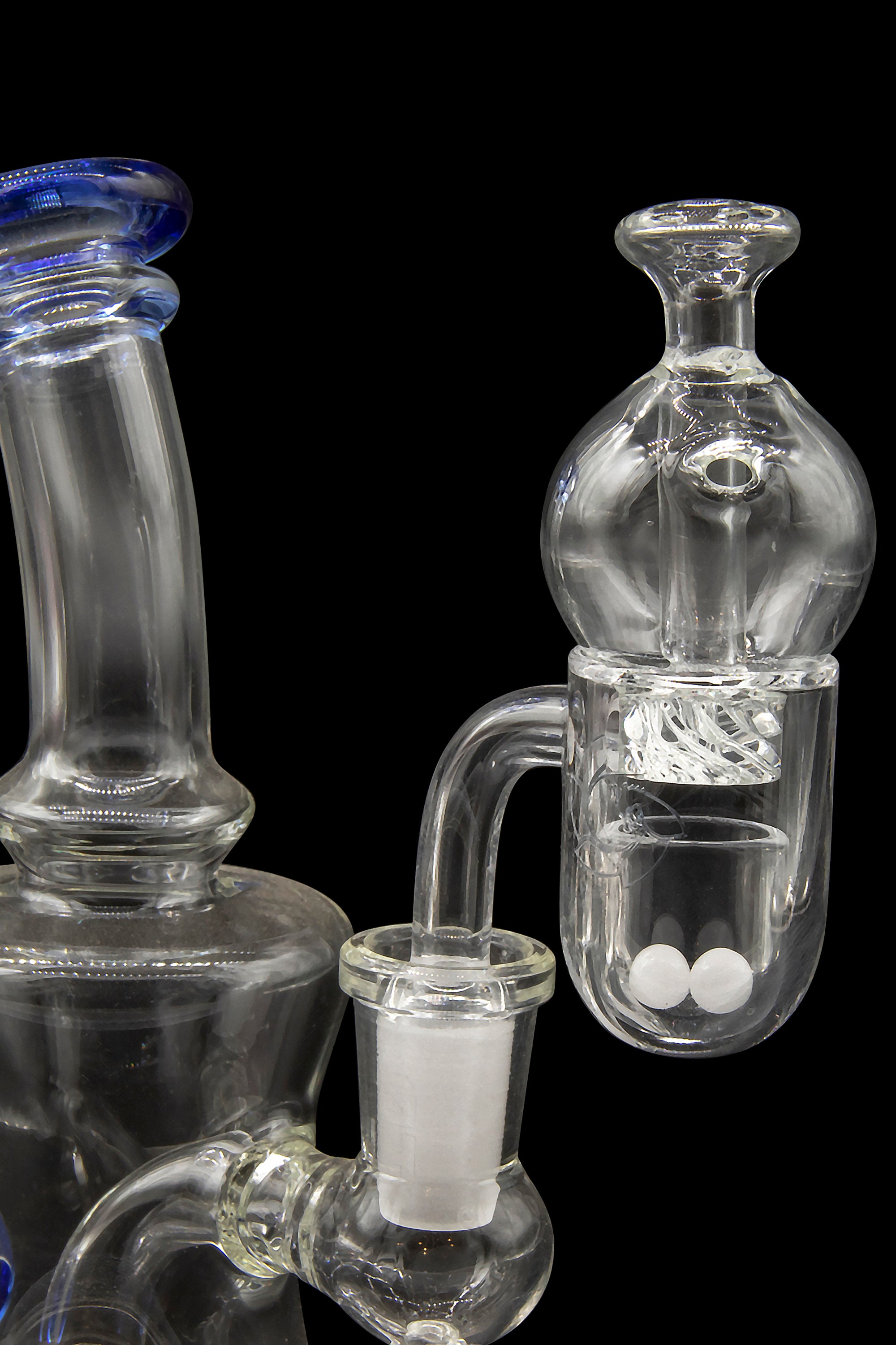 Clear glass bubbler and percolator water pipe with white packing material, isolated on a black background.