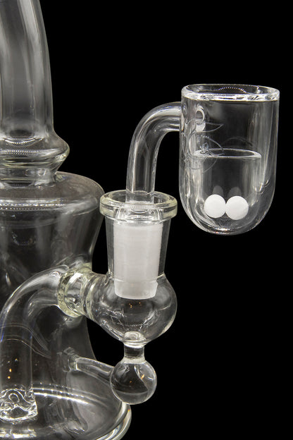 Clear glass water pipe (rig) with a quartz banger containing white cannabis concentrate (crumble or wax).