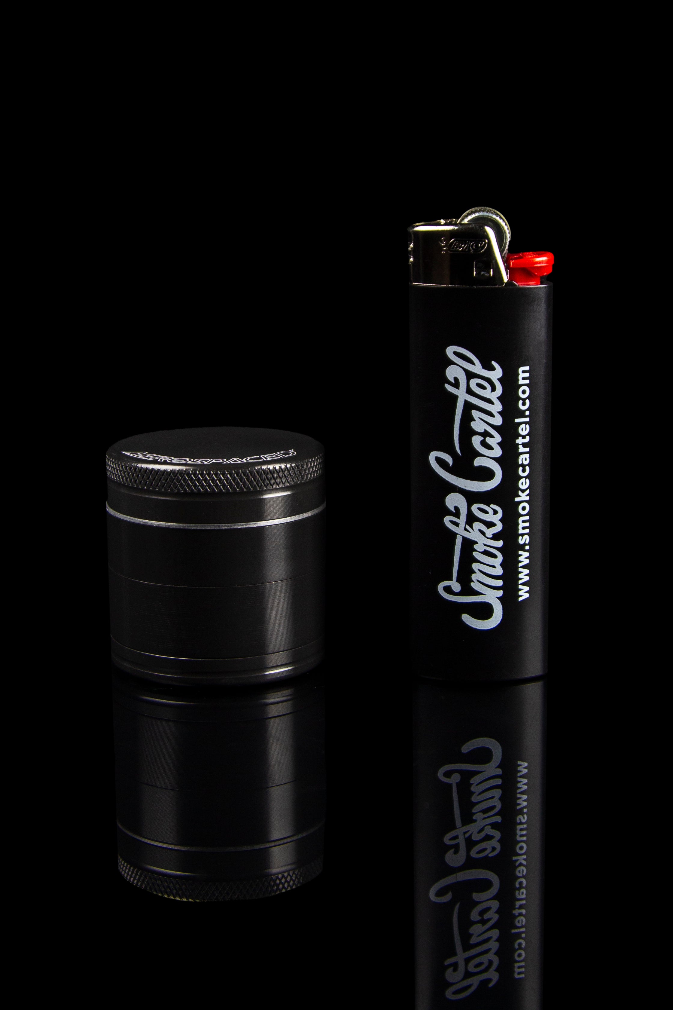 Black grinder and lighter with "Smoke Cartel" branding on a dark background.