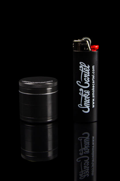 Black grinder and lighter with "Smoke Cartel" branding on a dark background.
