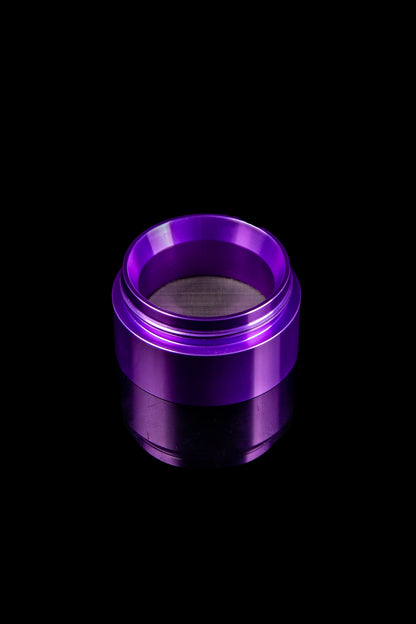 Purple cannabis grinder sieve or screen on black background.