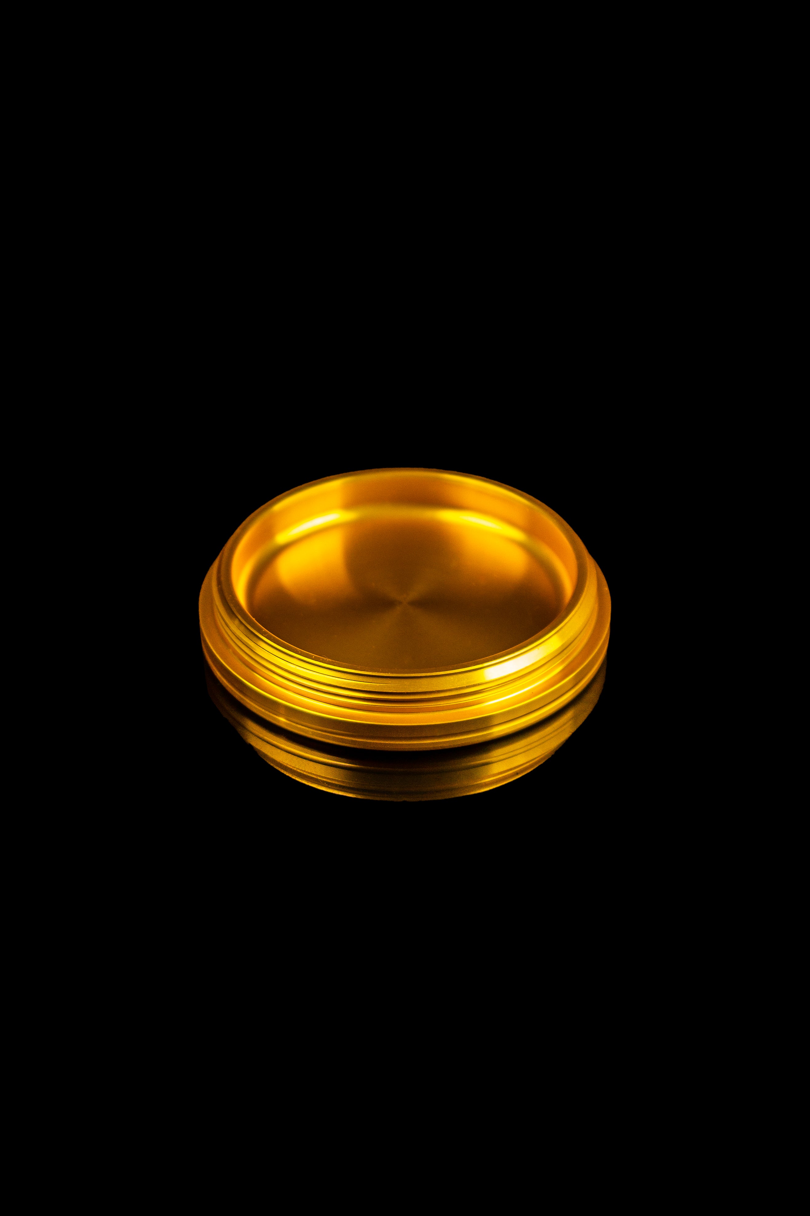 Golden metal stash jar on a black background.