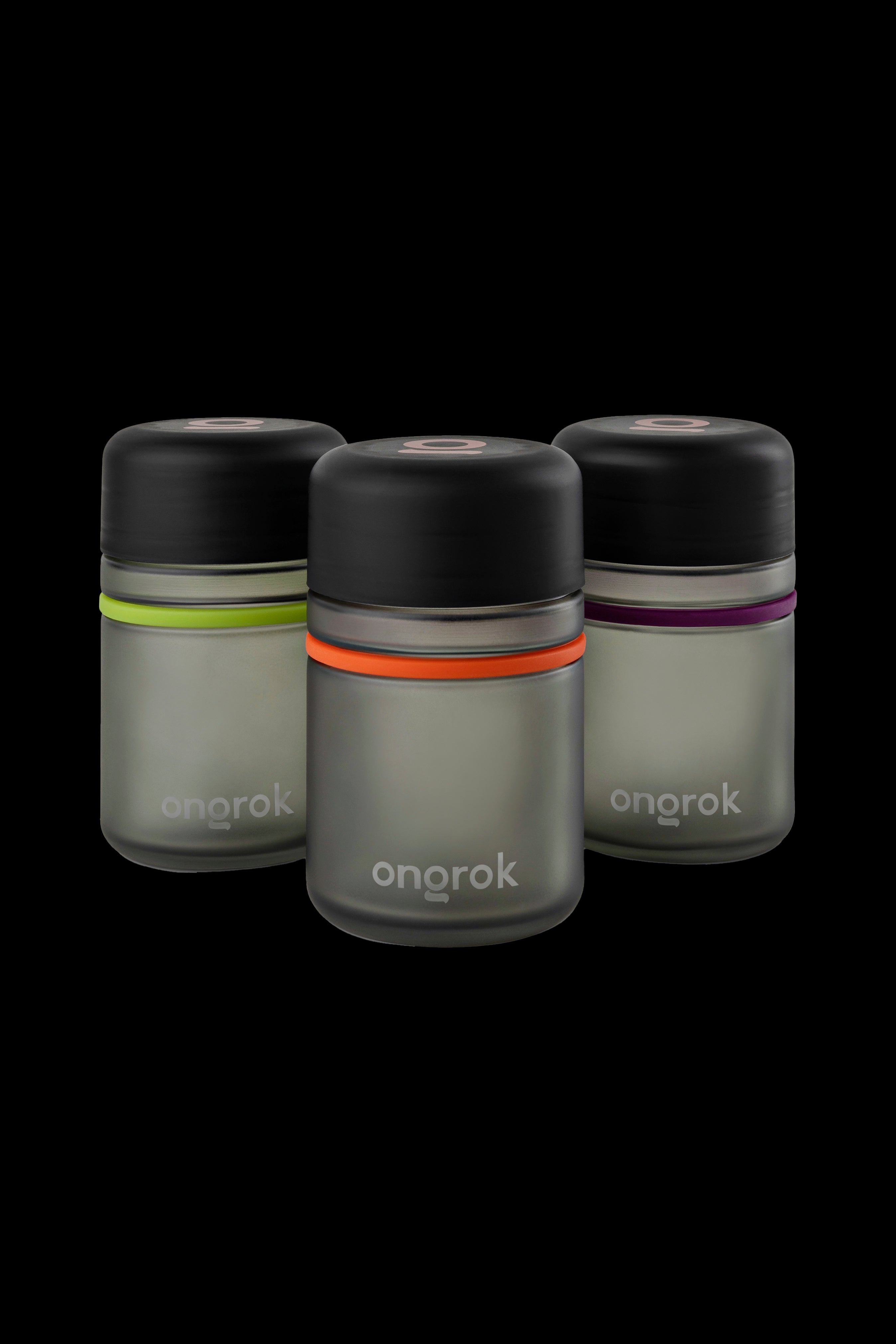 Three sleek, cylindrical Onrok cannabis oil vaporizers in translucent green, orange, and purple hues against a black background.