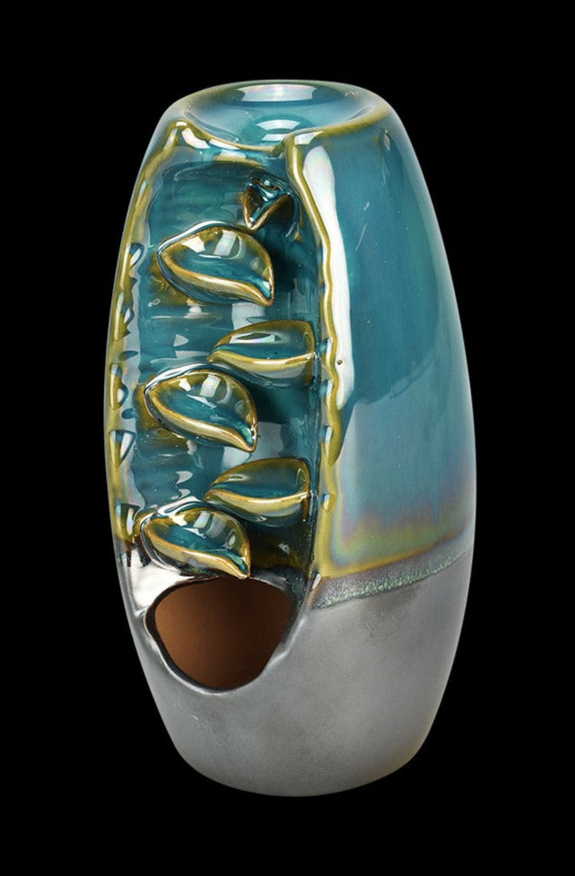 A slightly angled view of the Back Flow Magic Ceramic Incense Burner, showcasing its smooth, teal-colored ceramic with a narrow opening.