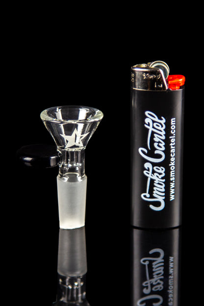 Close-up, side view of the Famous Brandz Glass Beaker Ice Bong - Space bowl piece with a white star decal beside a black lighter on a reflective black background