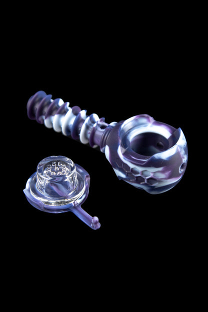 Purple and white glass pipe and accompanying glass bowl against a black background.