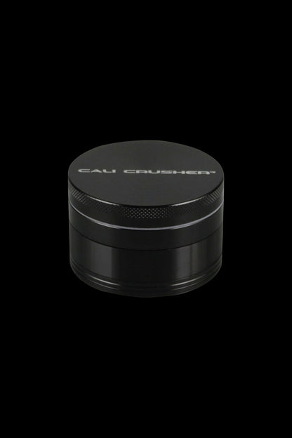 Front view of the Cali Crusher O.G. 4-Piece Grinder, a metallic grinder with a textured top and sleek cylindrical shape.