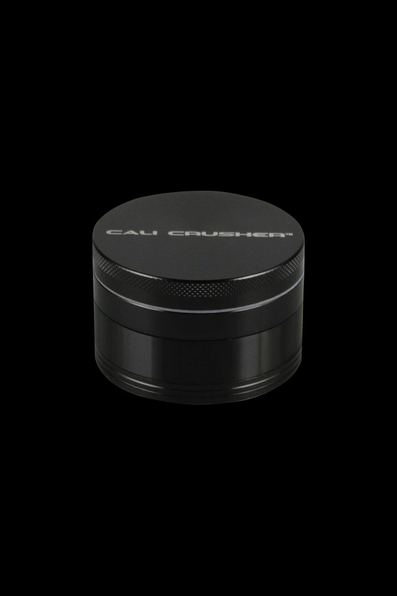 Front view of the Cali Crusher O.G. 4-Piece Grinder, a metallic grinder with a textured top and sleek cylindrical shape.
