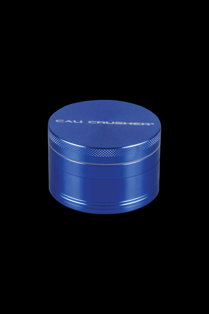 A close-up of the Cali Crusher O.G. 4-Piece Grinder, showcasing its metallic blue finish and cylindrical shape.