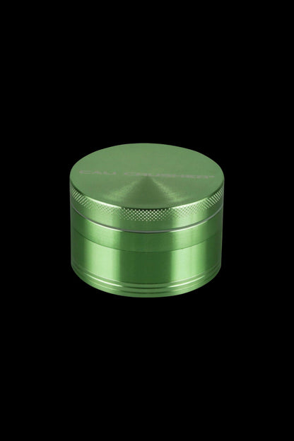 A centered, angled view of the Cali Crusher O.G. 4-Piece Grinder, showcasing its metallic finish and circular design.