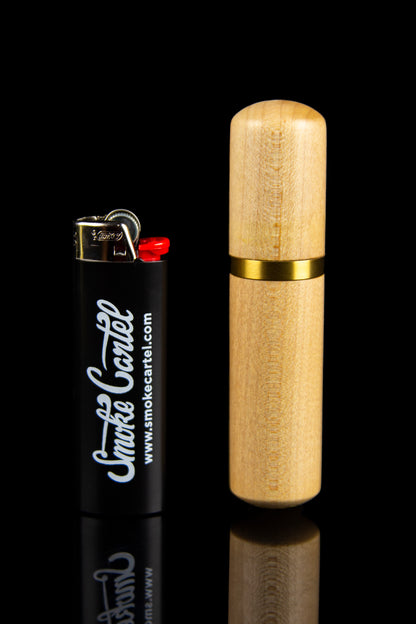 Gold grinder and lighter with "Smoke Cartel" branding on a black reflective surface.
