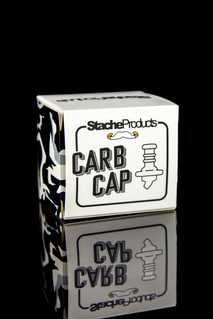 White box labeled “CARB CAP” with a graphic of a carb cap and the reflection of the box, against a black background.