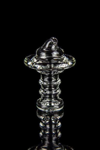 Clear glass dab rig with intricate spiraled design, isolated on black.