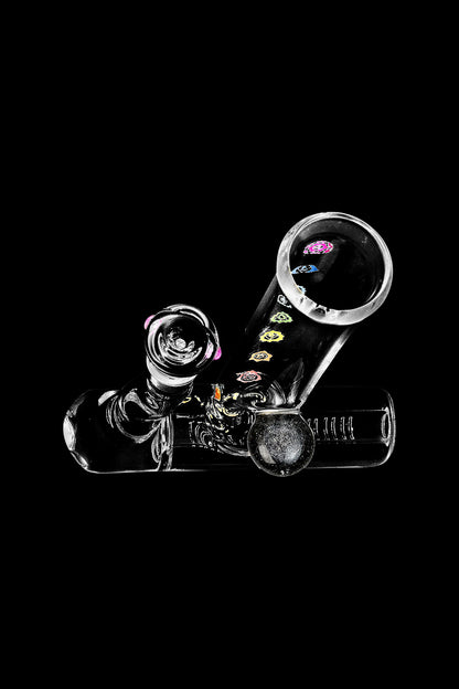 A studio shot of the Chakra Inline Perc Lazy Water Pipe, displaying its clear glass construction and curved design from a low angle.