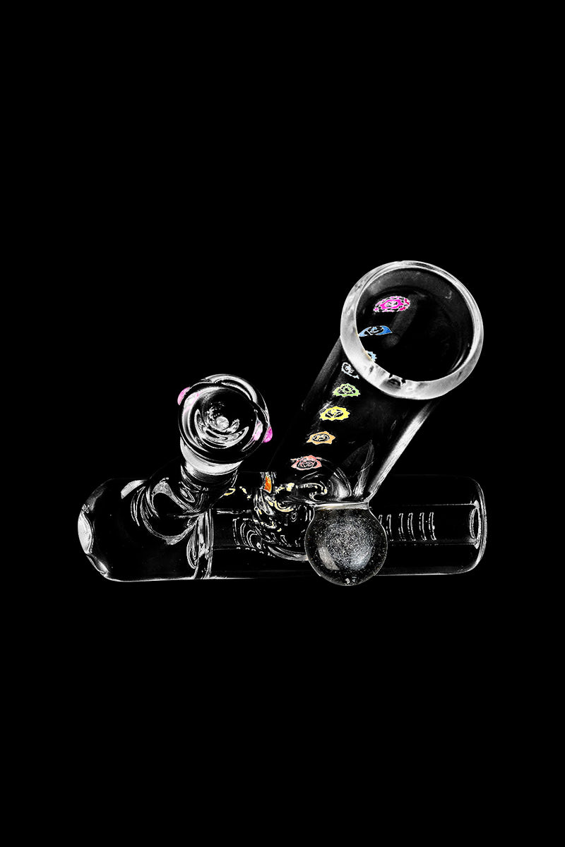 A studio shot of the Chakra Inline Perc Lazy Water Pipe, displaying its clear glass construction and curved design from a low angle.