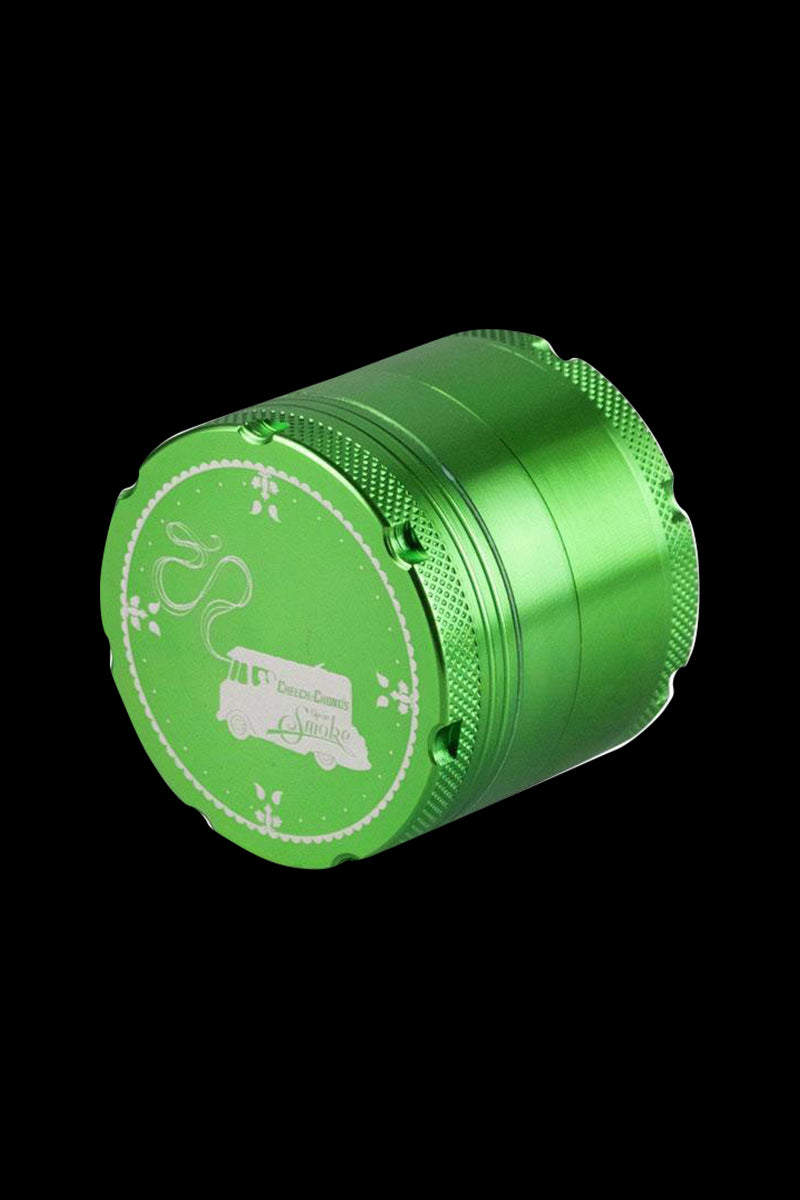 A close-up shot of the Cheech & Chong's Up In Smoke Grinder, showcasing its metallic, multi-tiered design from a slightly elevated angle.