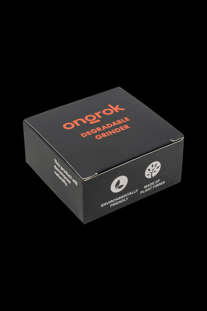 A black, square cannabis grinder box labeled "Onorak Degradable Grinder" with eco-friendly messaging including "Made of Plant Fibers" and "This product will decompose naturally."