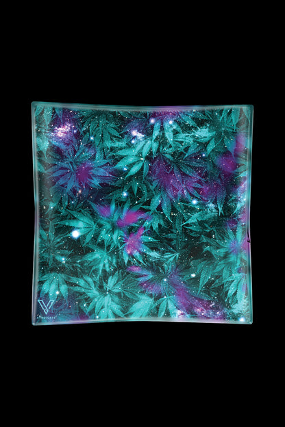 A vibrant glass ashtray with a galaxy-inspired design featuring cannabis leaves and sparkling accents, against a black background.