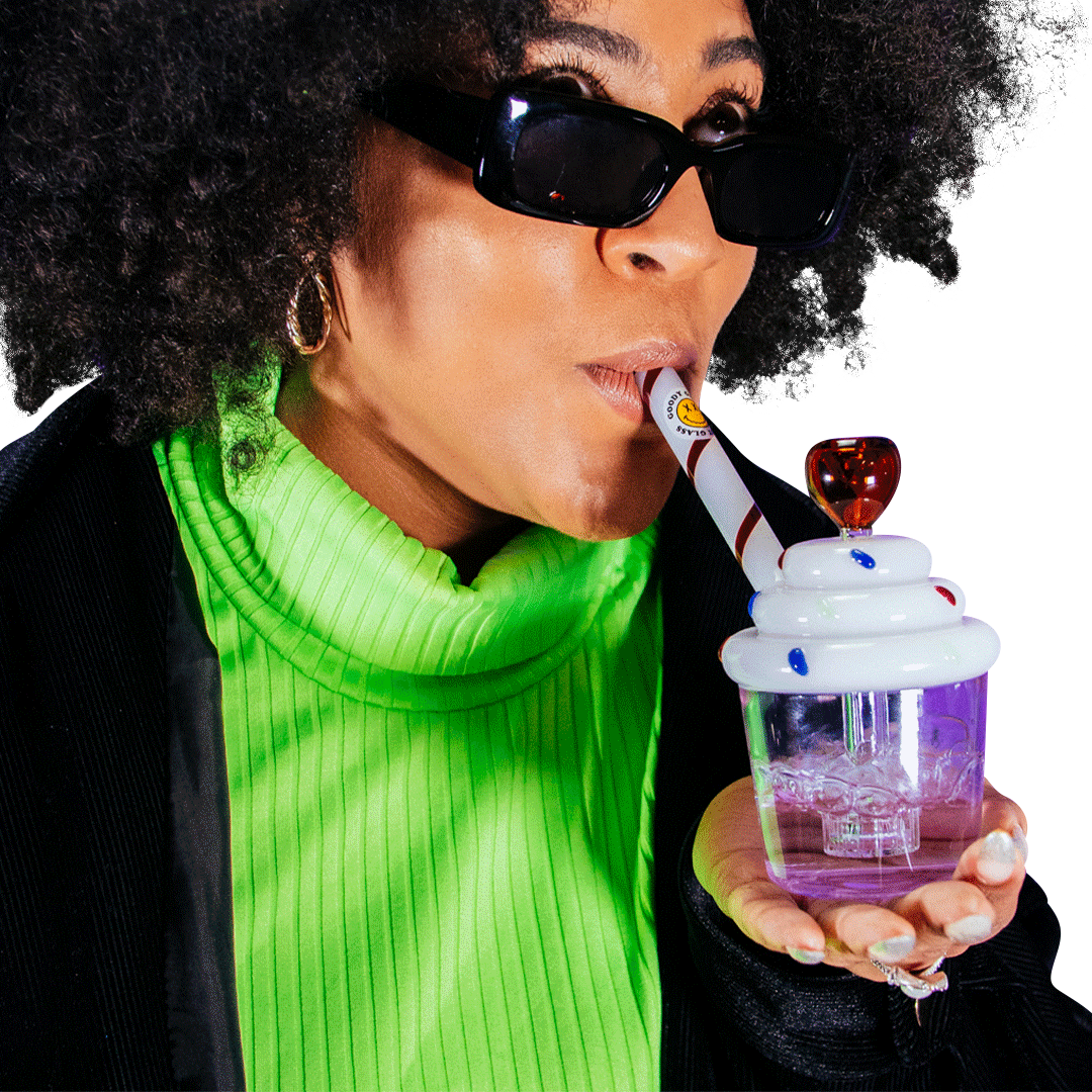 A close-up, angled view shows a person holding the Goody Cupcake Bubbler, its colorful design contrasting with their green shirt.