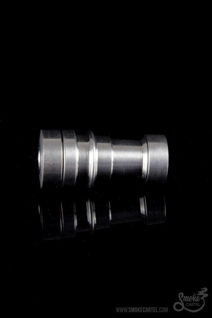 Silver cannabis oil burner with mirrored reflection on black background.