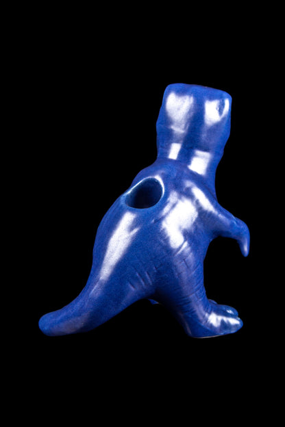 Blue dinosaur-shaped glass pipe against a black background.