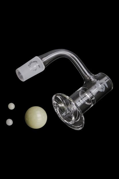 Clear quartz banger with carb caps and dab balls against a black background.