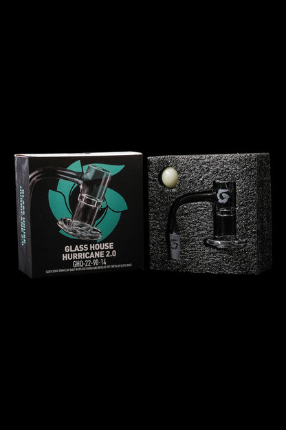 Product packaging for a Glass House Hurricane 2.0 cannabis water pipe, shown with the pipe itself and a small green ball accessory.
