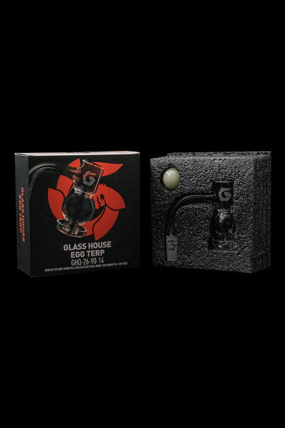 Black packaging for “Glass House Egg Terp” cannabis accessory, alongside a black textured portable vaporizer.