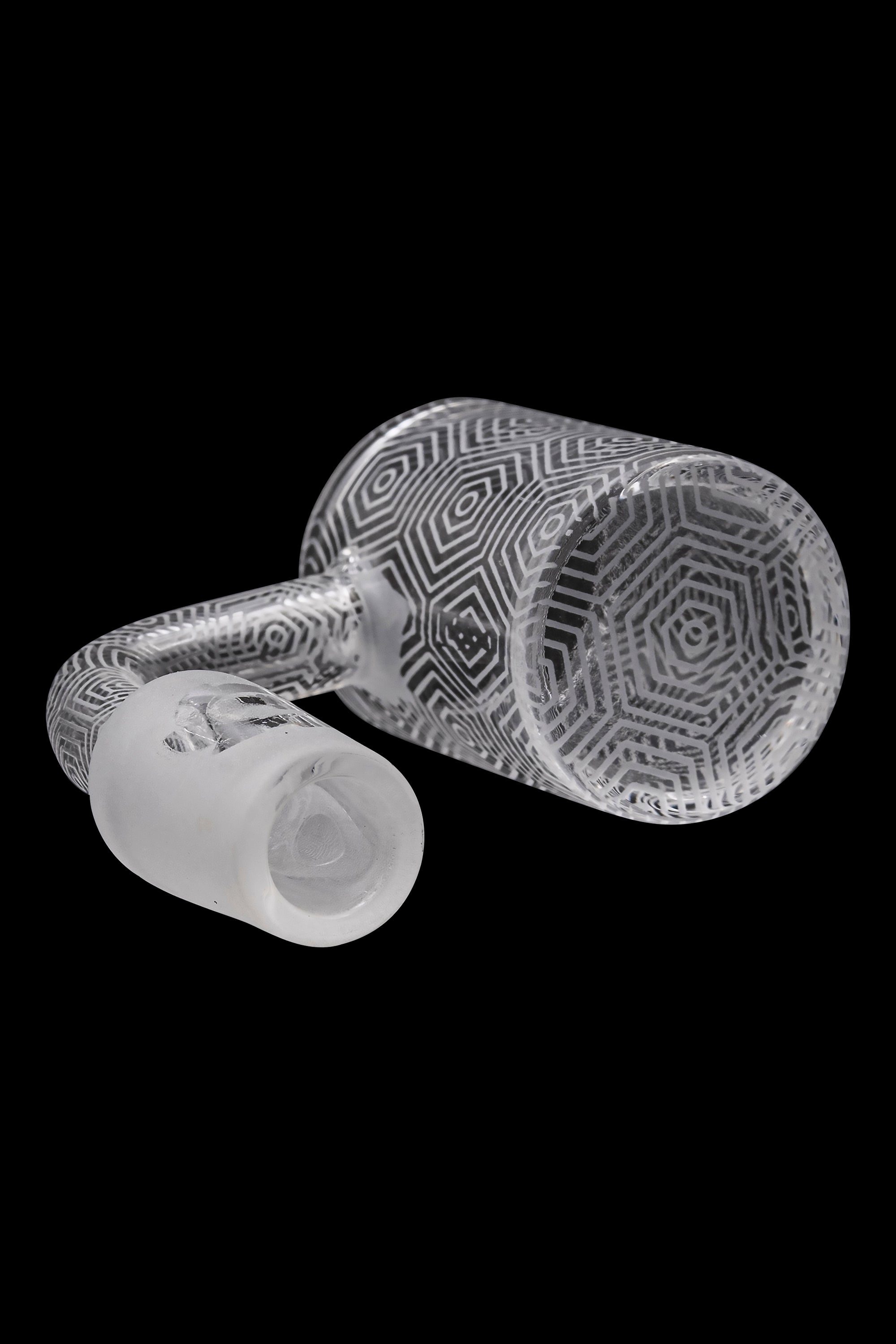 Clear glass bubbler with intricate geometric patterns, isolated on a black background.