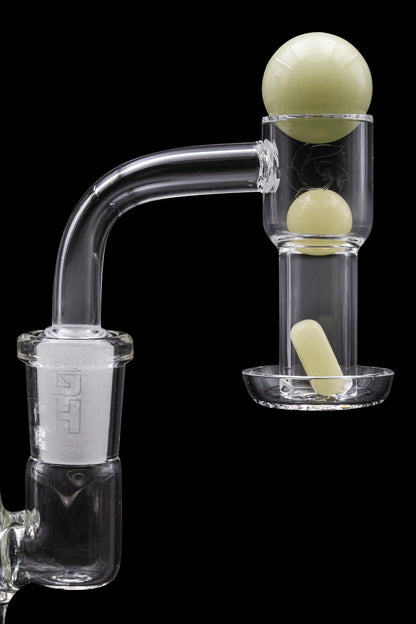 Clear glass dab rig with pale green accents and spherical bubbles, against a black background.