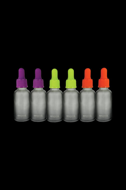 Six dark glass bottles with colorful dropper tops, labeled “onarak,” arranged in a row on a black background.
