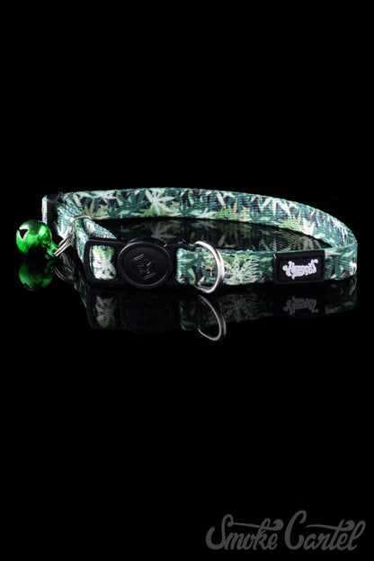 Close-up of the HeadyPet Cat Collar, a patterned collar with a silver bell and buckle against a dark backdrop.