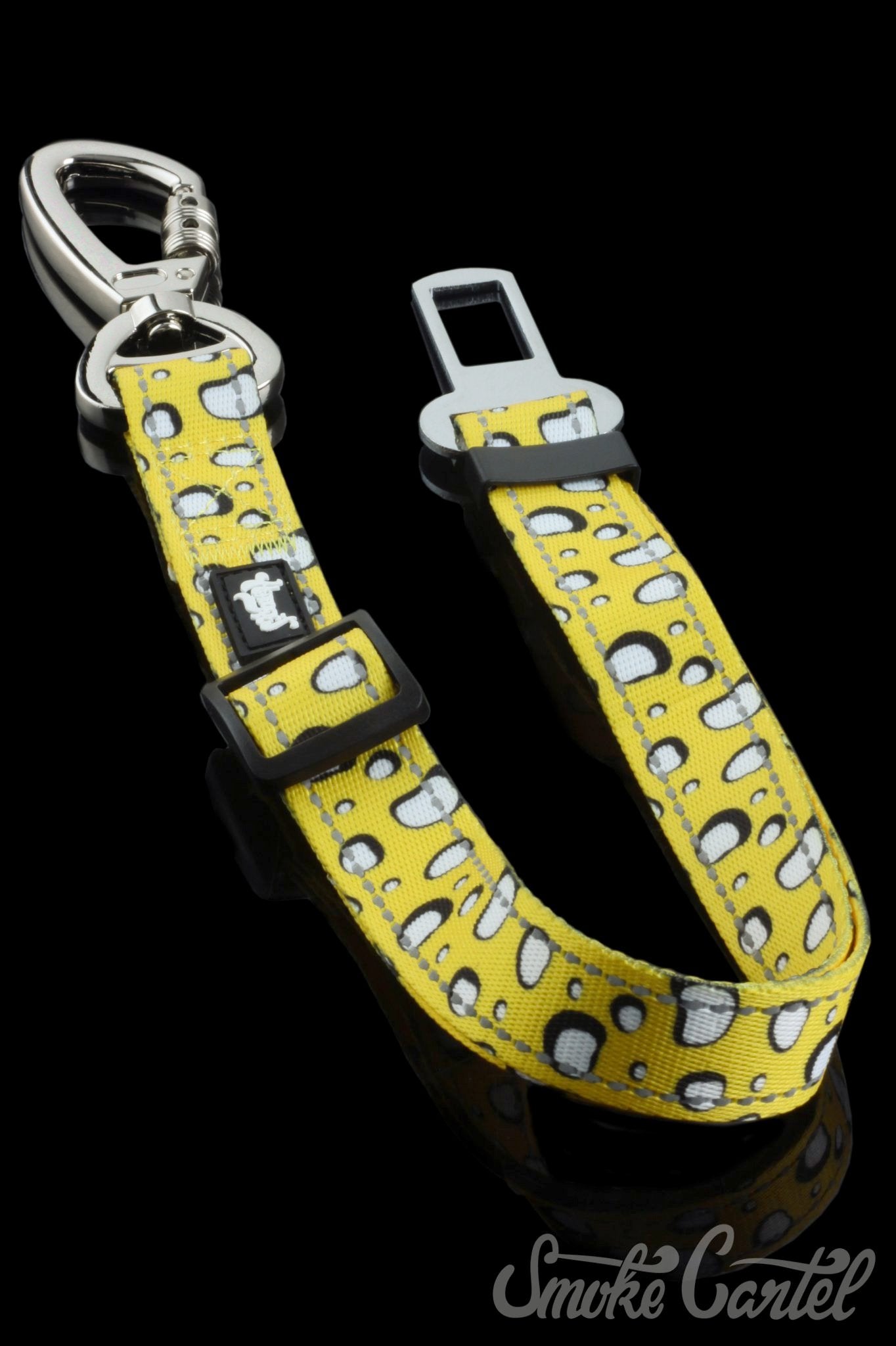 A close-up, angled view of the HeadyPet Seat Belt, a colorful patterned strap with a metal buckle and loop.