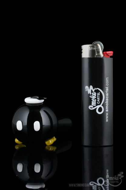 The Empire Glassworks Time Bomb Spoon, a clear glass piece, is displayed in a dynamic angled shot.