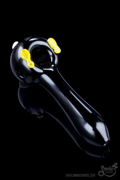 A three-quarter view of the Empire Glassworks Time Bomb spoon, showing its dark glass construction and curved design.