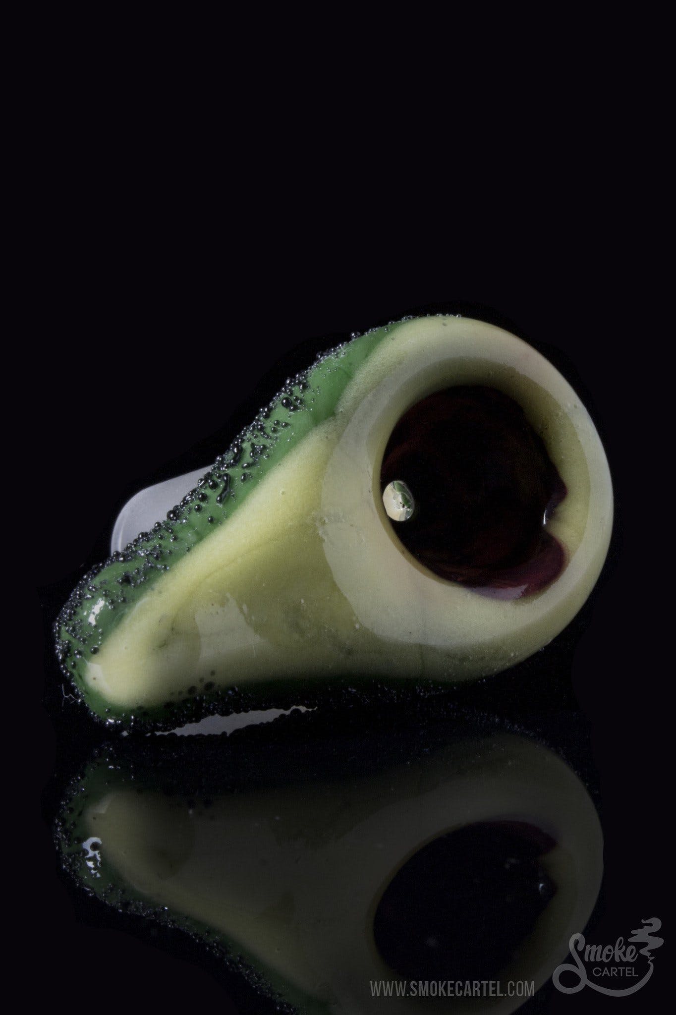 Close-up shot of the Empire Glassworks "Avocadope" Flower Bowl, reflecting its green, textured glass on a dark surface.